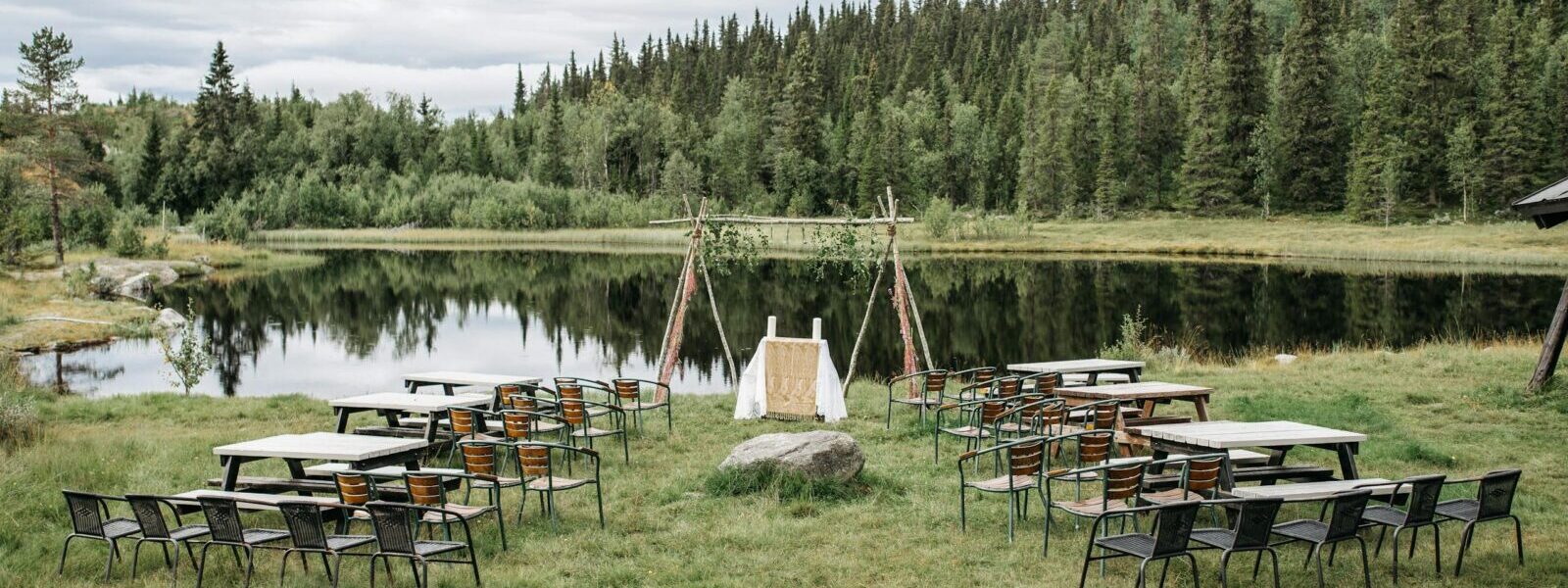 Beautiful outdoor setup by a serene lake surrounded by lush greenery and trees.