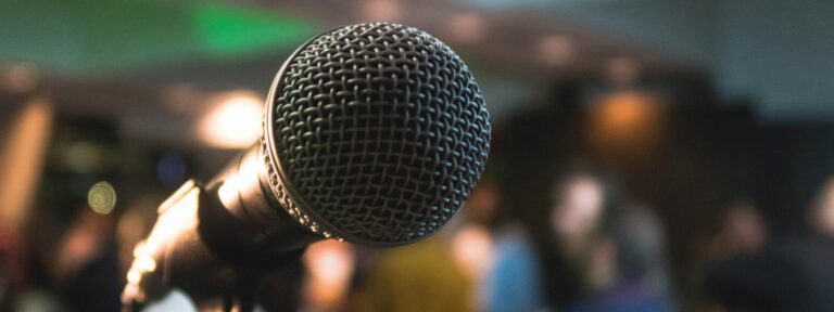 microphone in the front, blured pople in the back