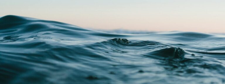 Tranquil ocean waves under a soft sunset sky.